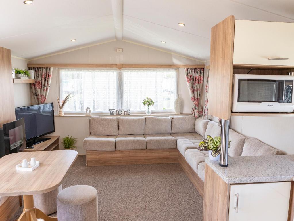 a living room with a couch and a tv at Caravan Skegness 8 Berth in Skegness