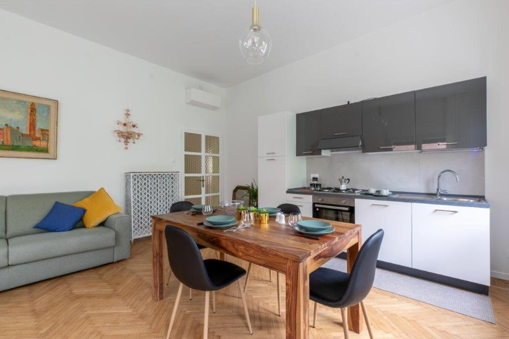 a kitchen and dining room with a wooden table and chairs at New Opening House 7 Lido Venice Near Ferry And Beach in Venice-Lido