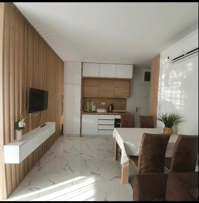 uma cozinha e sala de jantar com mesa e cadeiras em Sirius apartaments em Rafailovici