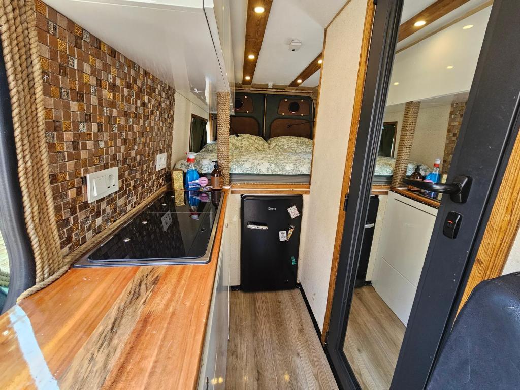 einen Blick auf einen Wohnwagen mit einem Bett und einer Küche in der Unterkunft Camperlife in Tbilisi City
