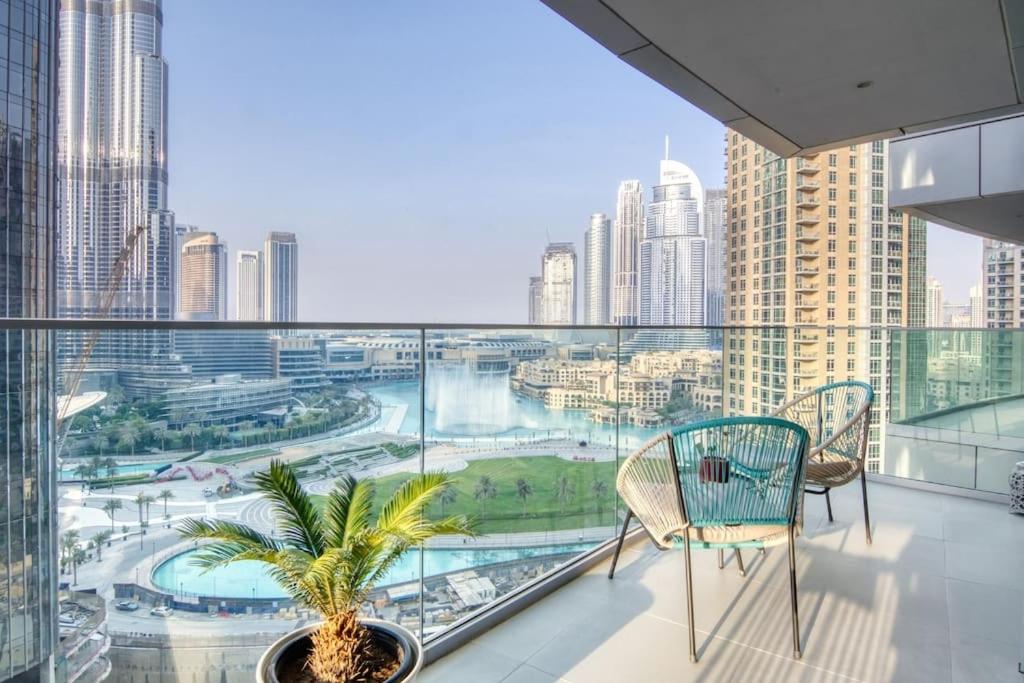 a balcony with two chairs and a view of a city at Spectacular Views of Burj & Fountain - 2 BR in Dubai