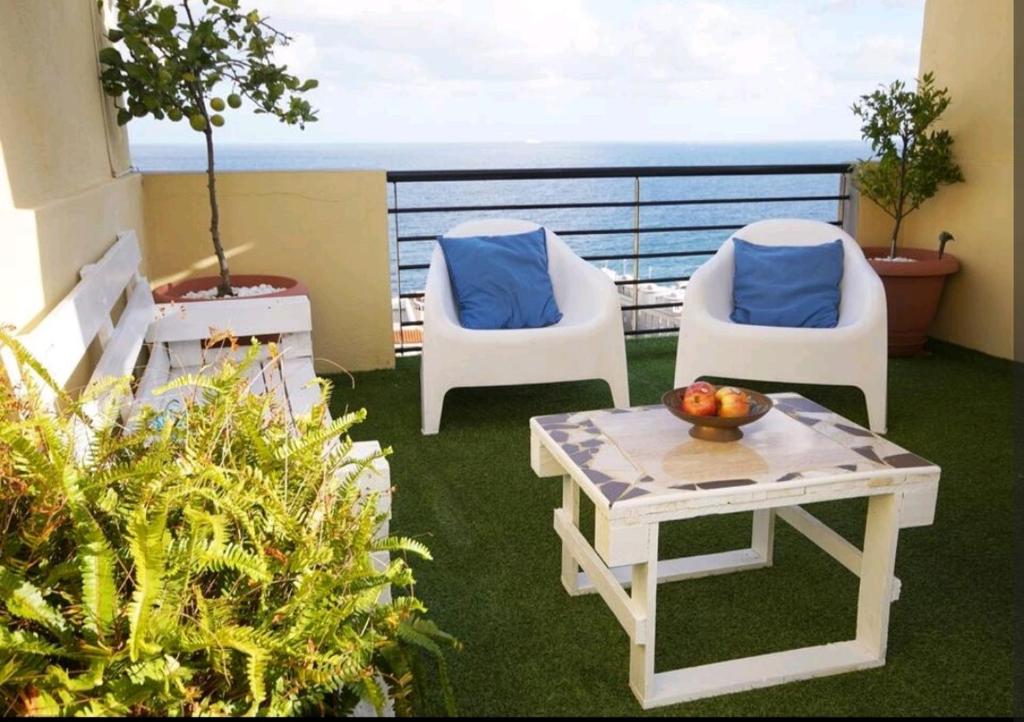 two chairs and a table on a balcony with the ocean at Balcón Atlantida in Candelaria