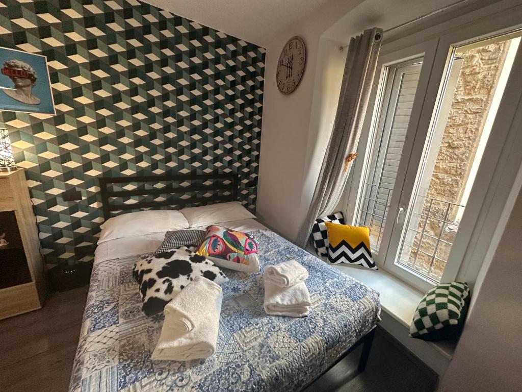 ein Schlafzimmer mit einem Bett mit Handtüchern darauf in der Unterkunft FEEL - Vivid Apartment in Bergamo