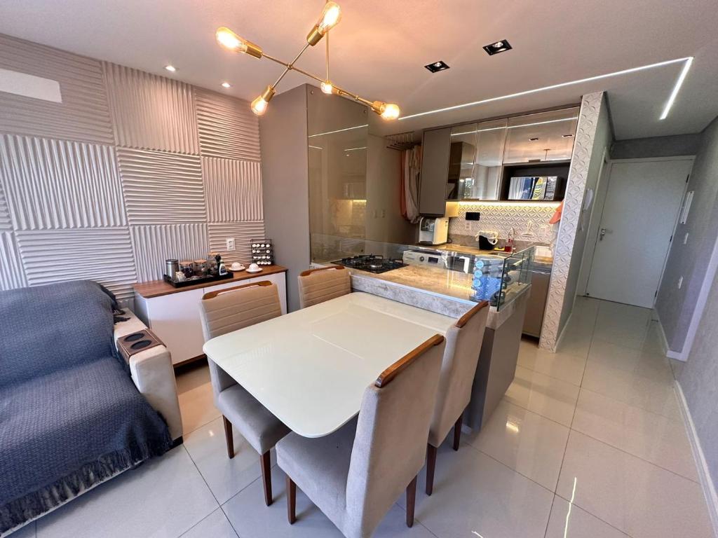 cocina y comedor con mesa blanca y sillas en Happy Living Resort, en Fortaleza