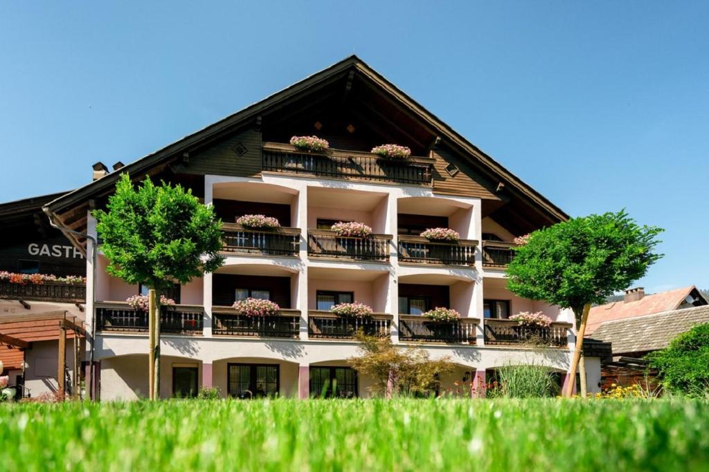 an apartment building with potted plants on the balconies at Der Tröpolacherhof Hotel & Restaurant in Tröpolach