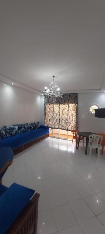 ein Wohnzimmer mit blauen Betten und einem Tisch in der Unterkunft sidi rahal in Zemmour Touirza