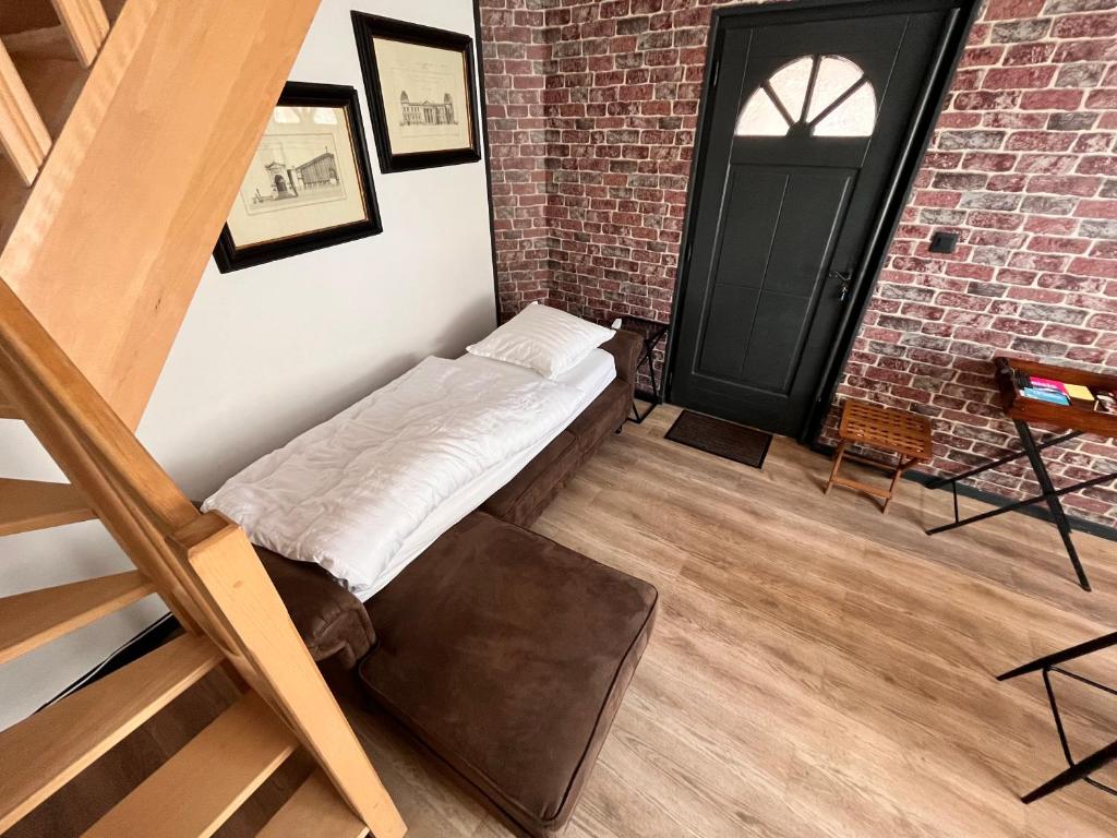 a bed in a room with a brick wall at North cosy house - Douai Centre in Douai
