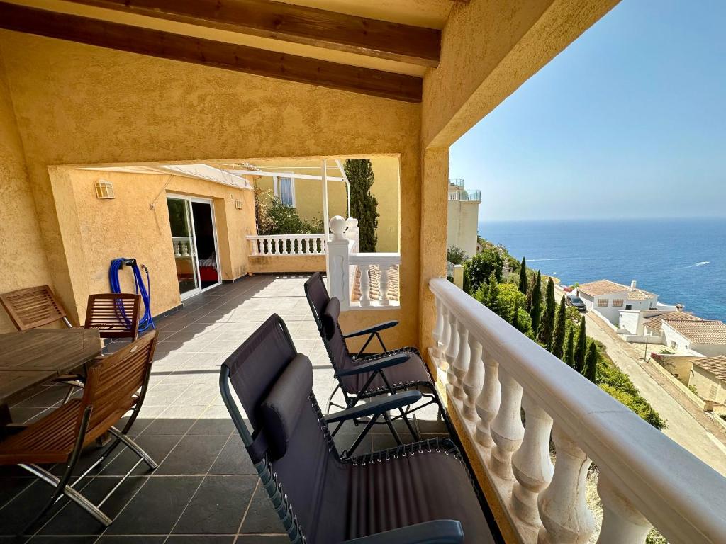 Un balcón con sillas y vistas al océano. en Villa Teresa, en Benitachell