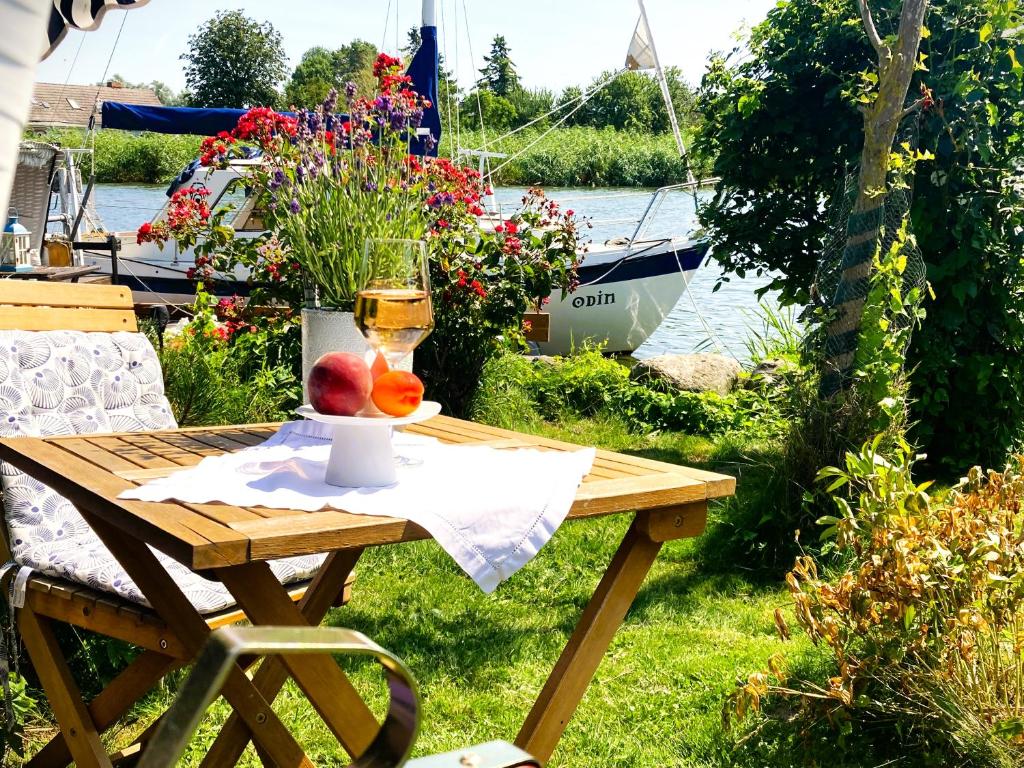 a picnic table with a glass of wine and fruit on it at Auszeit am Haffufer in Wilhelmshof
