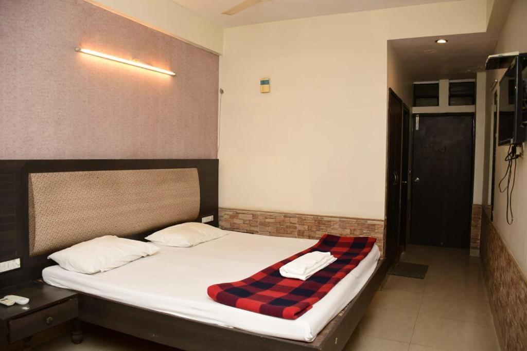 um quarto com uma cama com um cobertor xadrez em HOTEL GOMTI em Nagpur