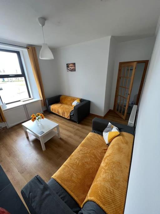 un soggiorno con divano e tavolo di Homely 3 bed town centre flat a Peterhead