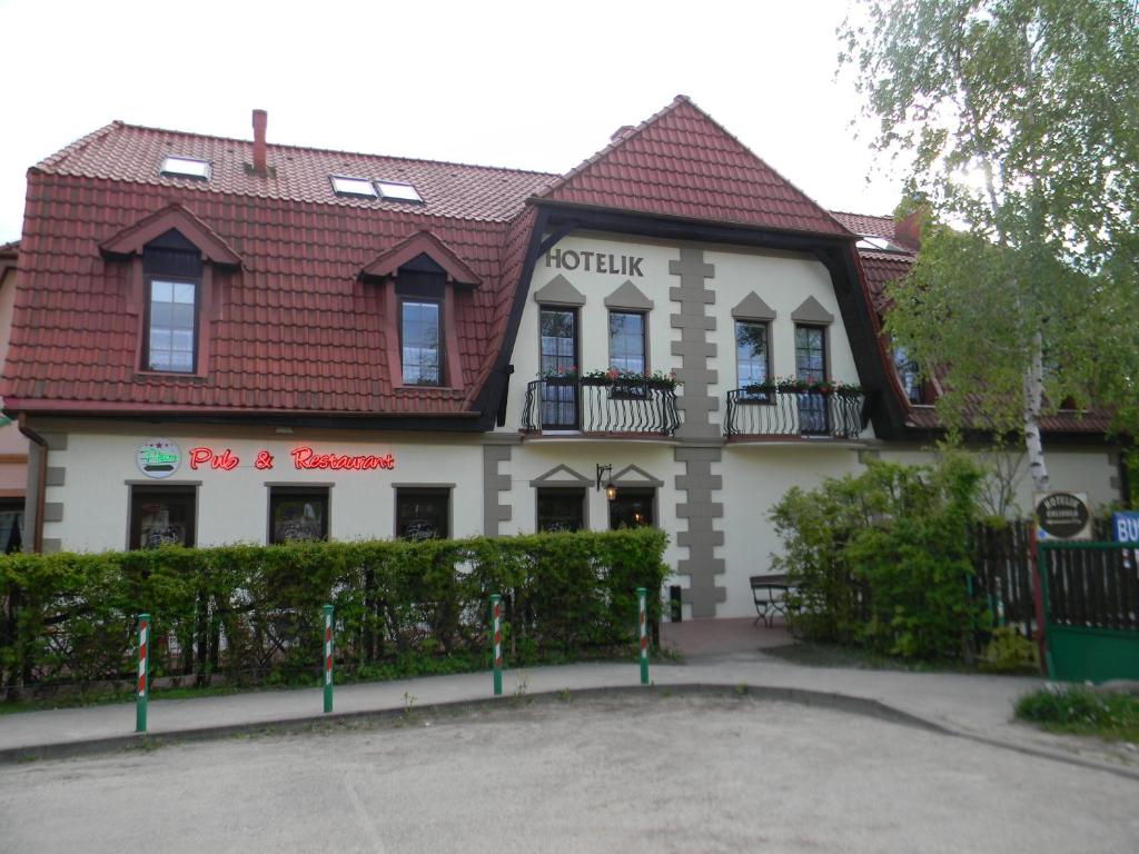 ein großes weißes Gebäude mit rotem Dach in der Unterkunft Prohibicja Peter's Pub in Mikołajki