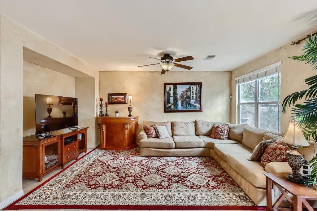 a living room with a couch and a flat screen tv at The Winner’s Retreat in Las Vegas