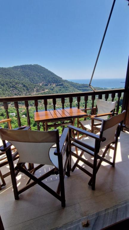 a table and chairs on a balcony with a view at Crissimo apartment in Panagia