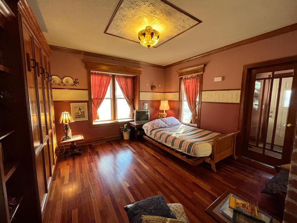 a bedroom with a bed and a wooden floor at Gwen's Place - Private 2nd Floor in Saint Ansgar