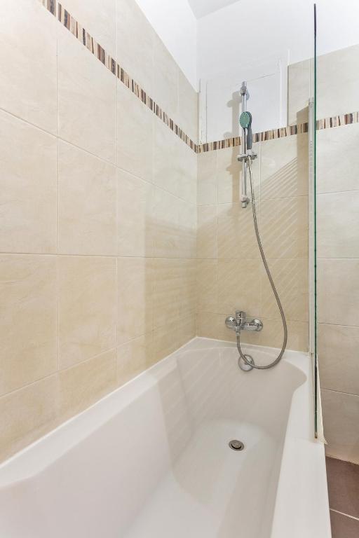 a bath tub with a shower in a bathroom at La Suite d&#39;Avenue Foche in Paris