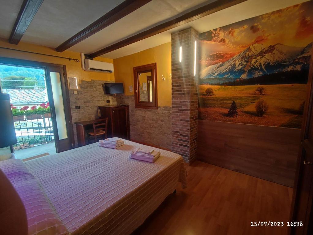 - une chambre avec un lit orné d'une peinture murale dans l'établissement Maison Manu, à Perosa Argentina