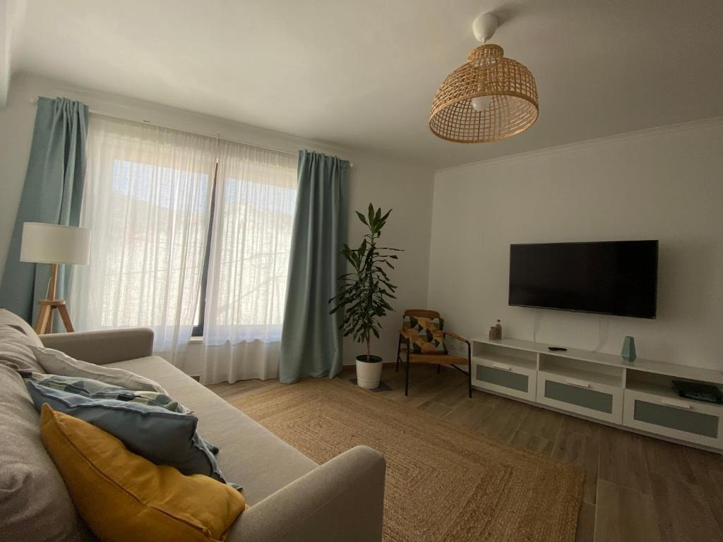a living room with a couch and a flat screen tv at Casa da Amoreira in Odeceixe