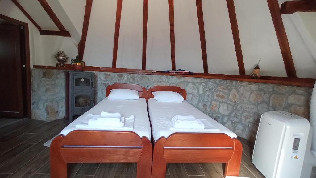 a bedroom with two twin beds and a refrigerator at Domaćinstvo Peković in Danilovgrad