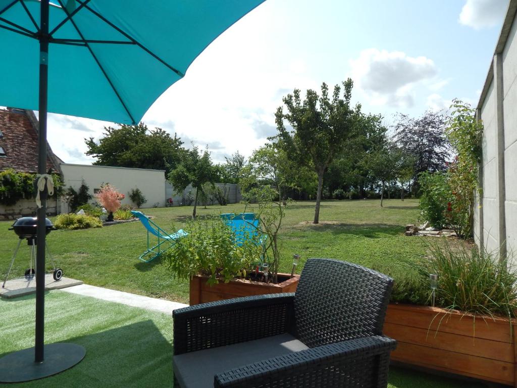 une terrasse avec une chaise, un parasol et une cour dans l'établissement Miss Tine, 