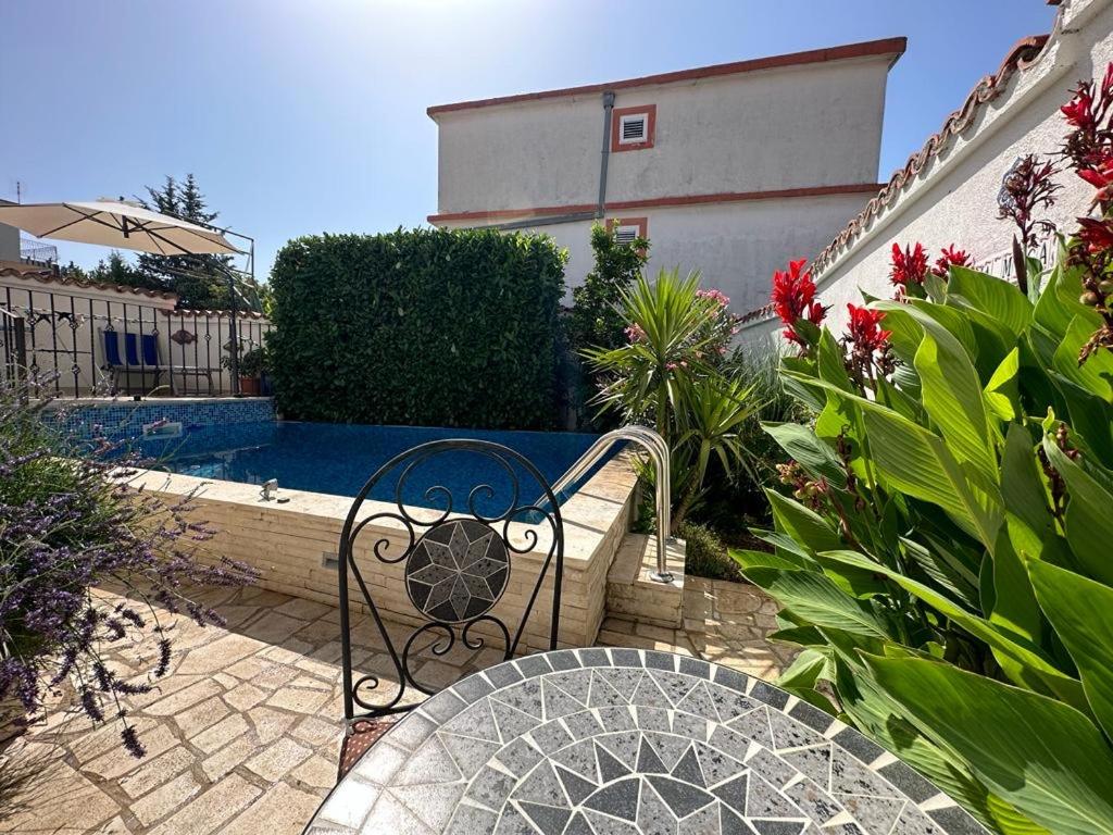a patio with a bench and a swimming pool at Villa La Miga in Dobra Voda