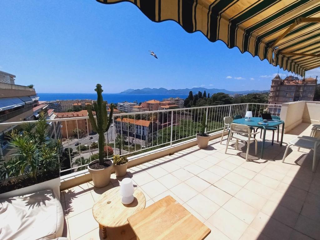 un balcon avec une table et une vue sur l'océan dans l'établissement Vue mer à couper le souffle - nouveau entièrement rénové, à Cannes