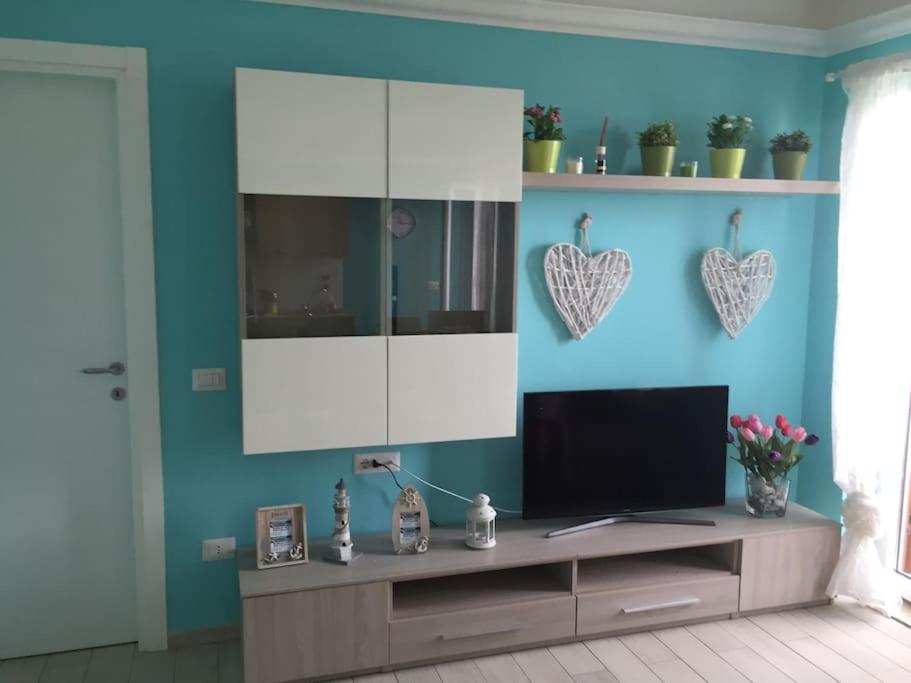 ein Wohnzimmer mit einem TV und einer blauen Wand in der Unterkunft Baia di Copanello IMMINENS MARI in Copanello