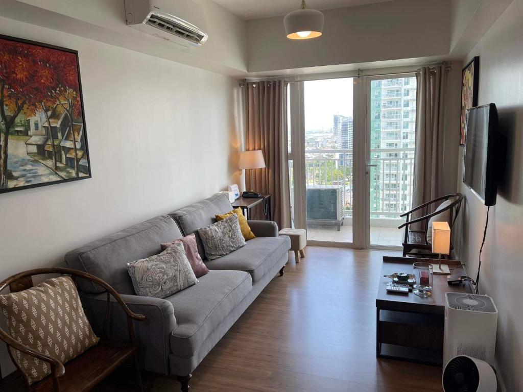 a living room with a couch and a tv at 2BR spacious stylish condo near mall in Cebu City
