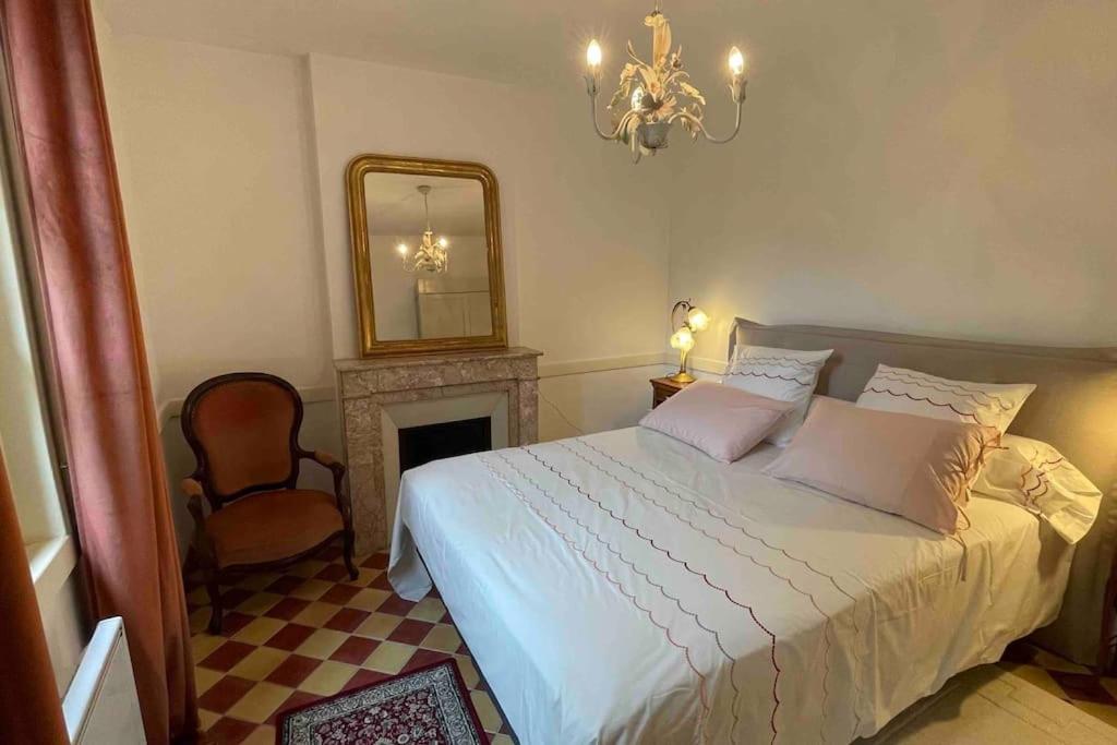 1 dormitorio con cama, espejo y silla en Gîte de charme Autun'Home en Autun