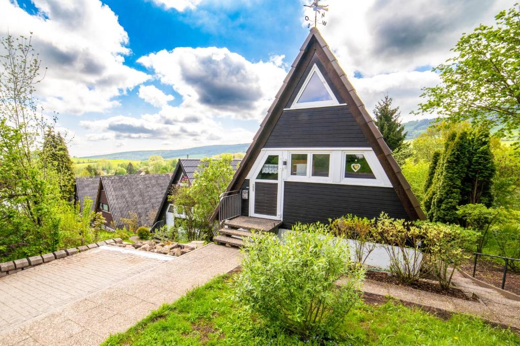 uma pequena casa preta com um telhado de gambrel em Ferienhaus Rhön-Auszeit em Bischofsheim an der Rhön