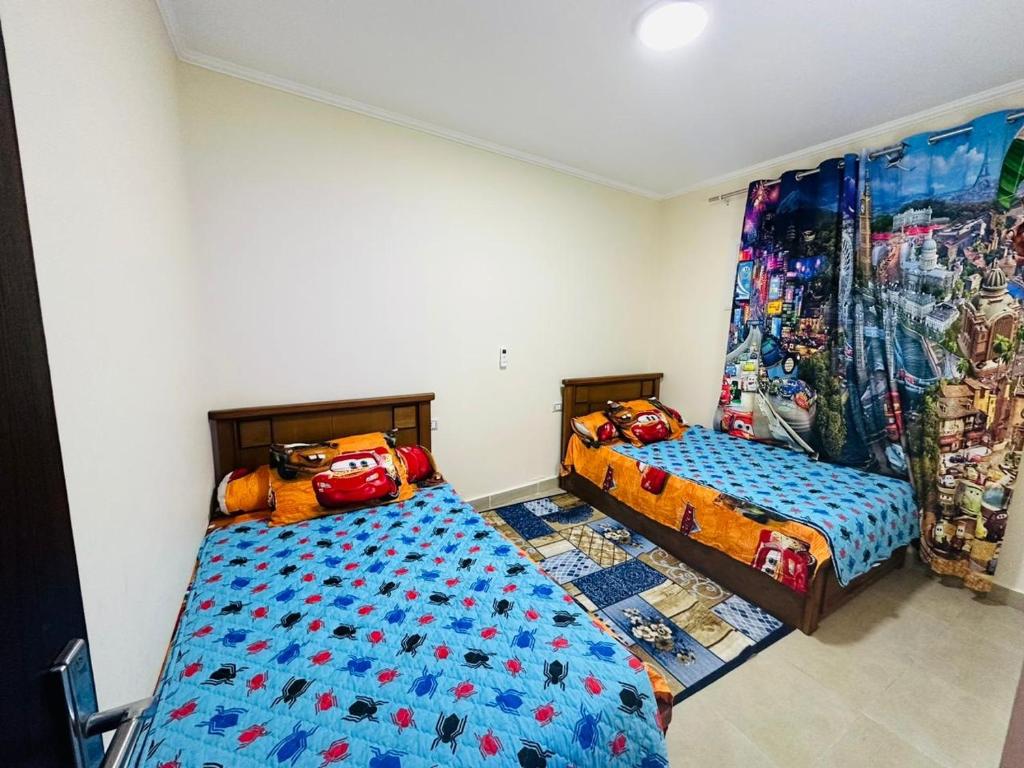 a bedroom with two beds and a curtain at Sia Lagoon 2 BR Porto Golf Marina Apartment with Garden Families only in El Alamein