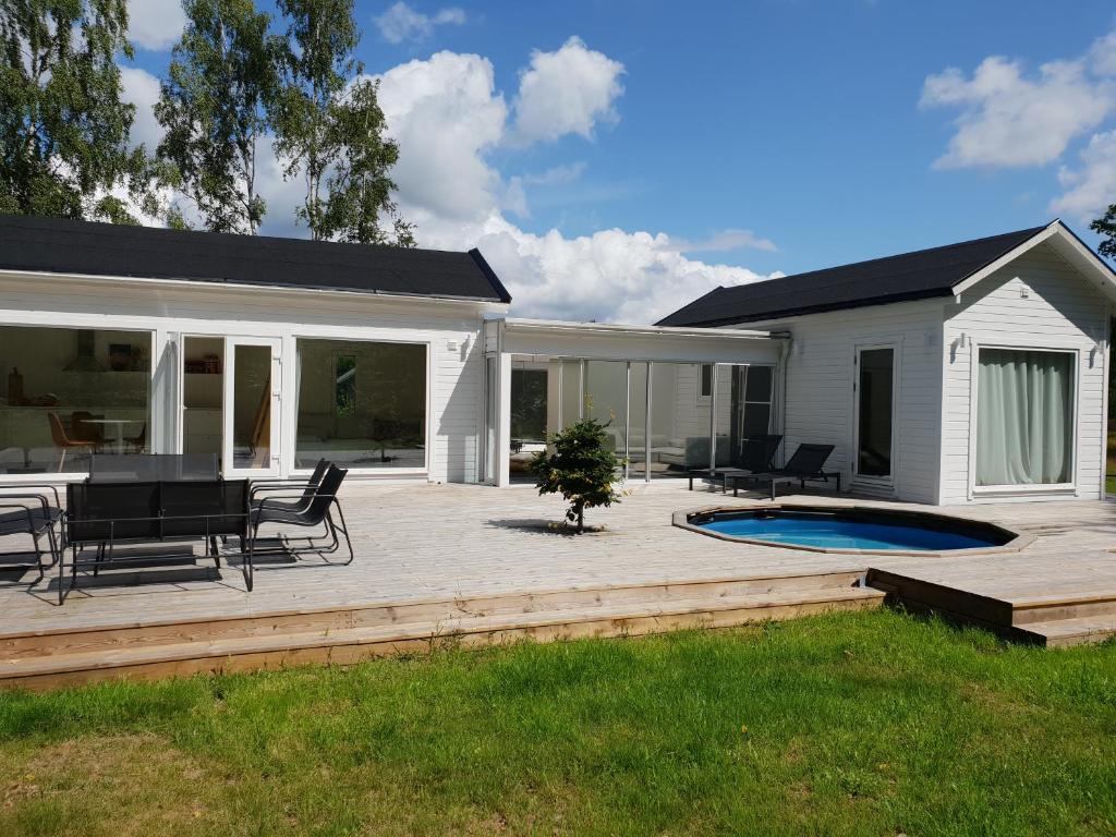 a patio with a table and chairs next to a house at The Black and White cabin with Spa bath in Västra Torup