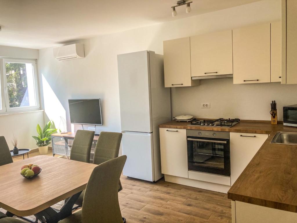 a kitchen and dining room with a table and a refrigerator at Apartment Mare in Pula