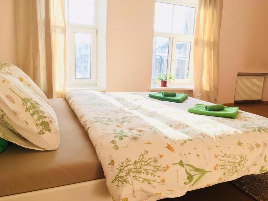 Una cama con dos almohadas verdes encima. en Tree House, en Riga