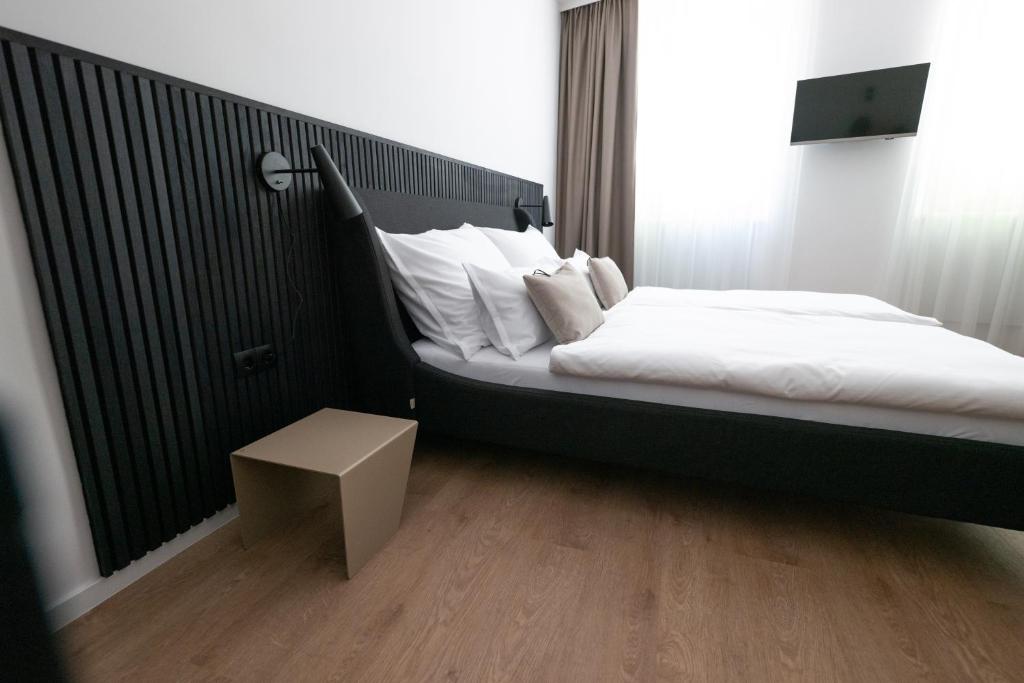 Bett mit weißer Bettwäsche und Kissen in einem Zimmer in der Unterkunft E D E L H O F . R O O M in Jois