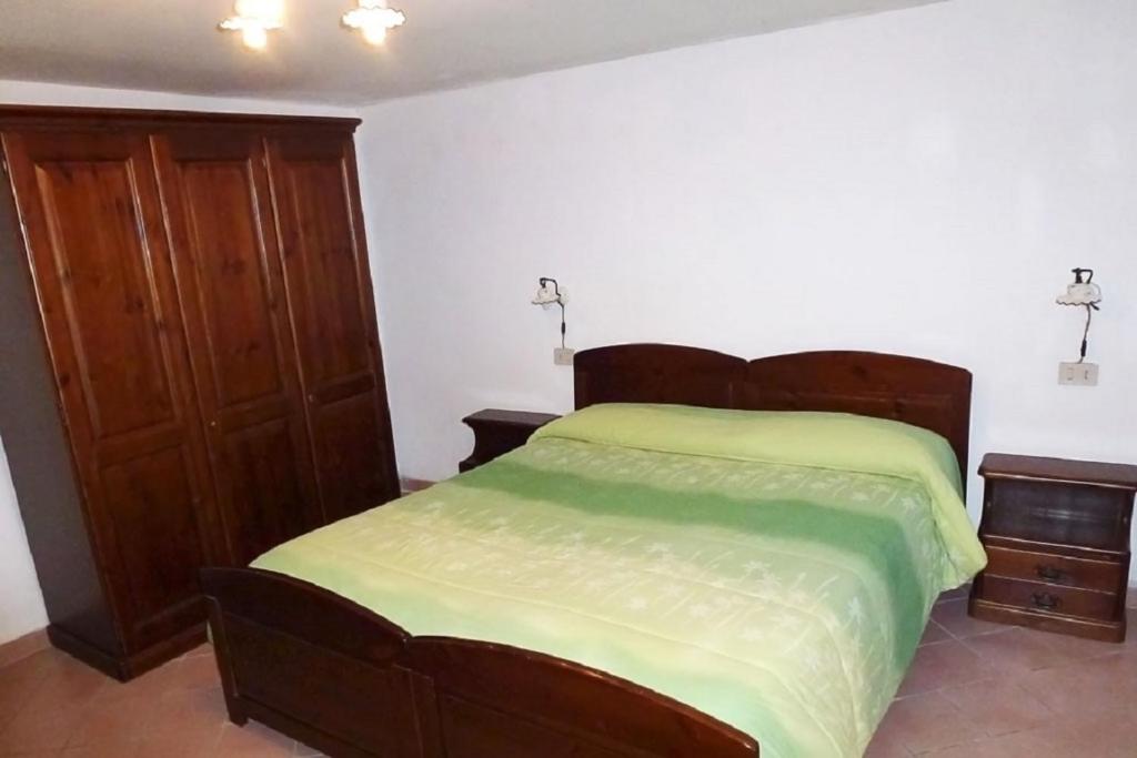 Schlafzimmer mit einem Bett und einem Holzschrank in der Unterkunft Agriturismo Macchiapiede in Sala Consilina