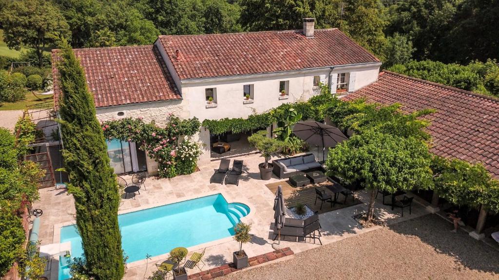 - une vue aérienne sur une maison avec une piscine dans l'établissement Le Logis de La Brumanderie - Saintes, à Fontcouverte