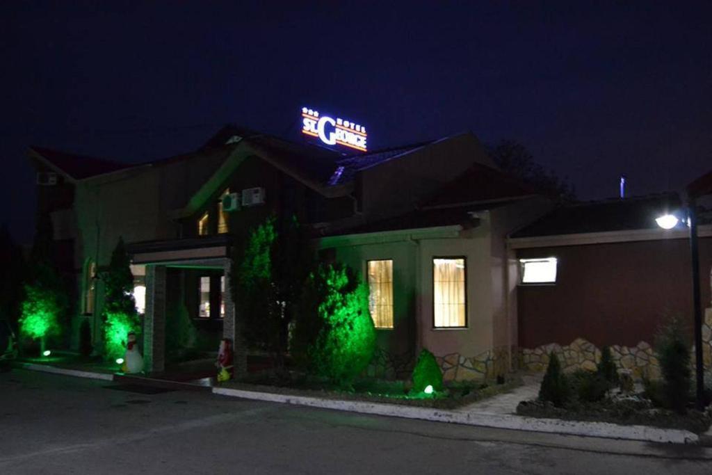 une maison avec des lumières vertes devant elle la nuit dans l'établissement Saint George, à Strumica