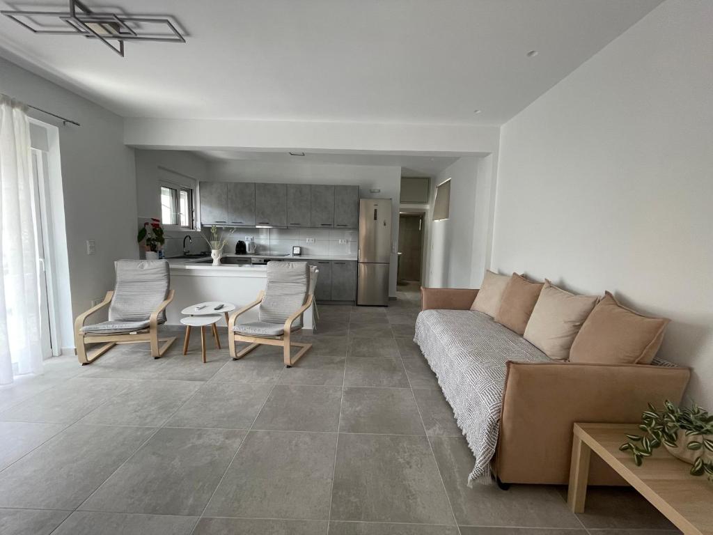 a living room with a couch and chairs and a kitchen at Daniel's House - Palaia Fokaia in Palaia Fokaia
