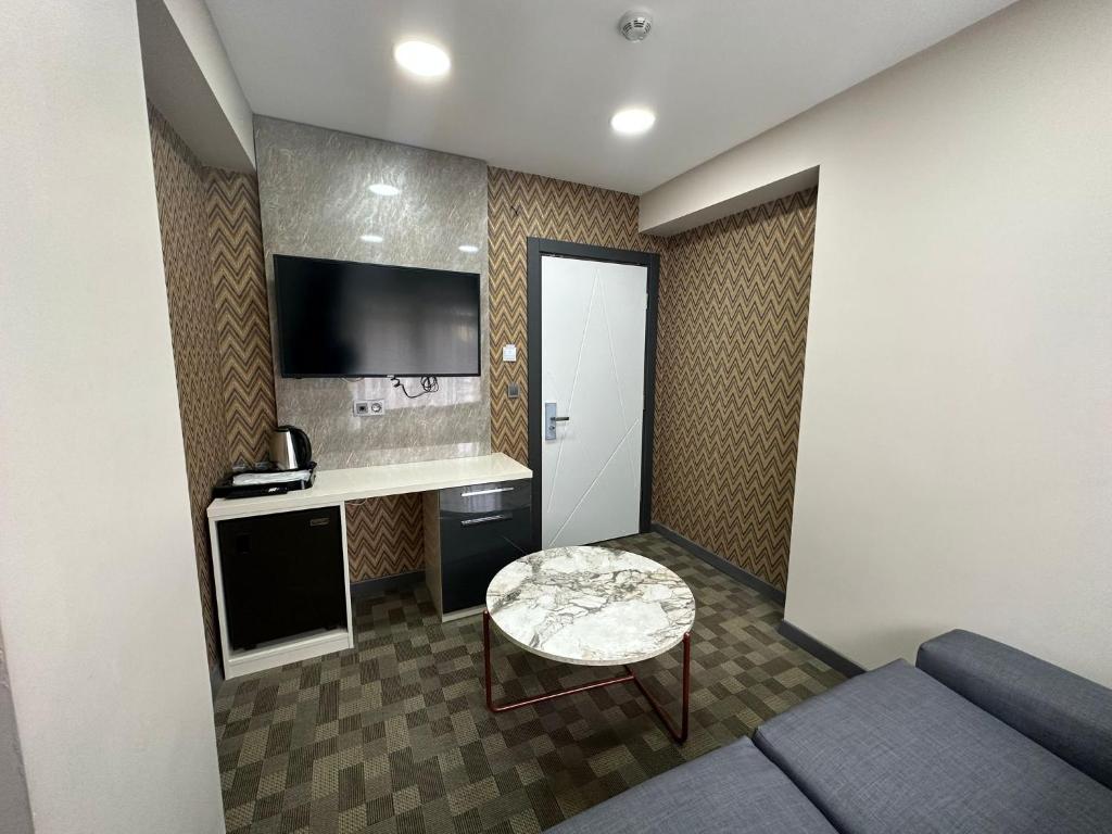 Habitación pequeña con sofá y mesa. en FLORYA EXPRESS OTEL, en Estambul