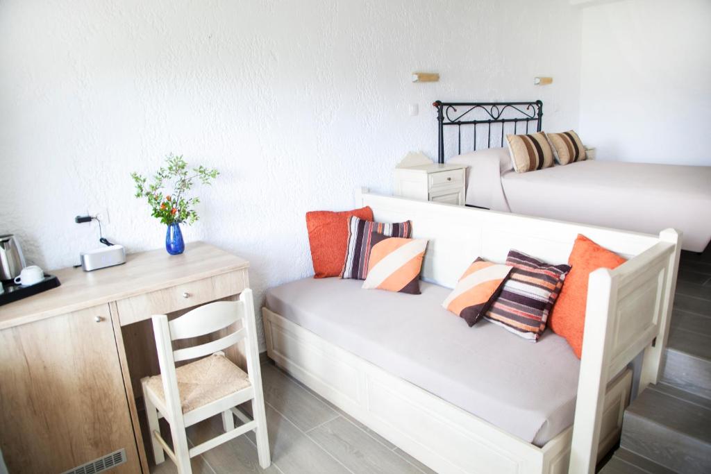 a room with two beds and a bench with pillows at Elpida Village in Istro