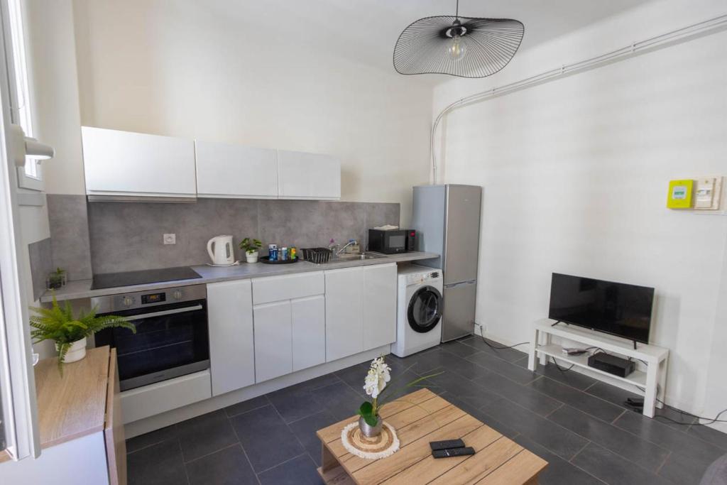 a kitchen with white cabinets and a table at Superbe appartement à 250 m de la mer in Toulon