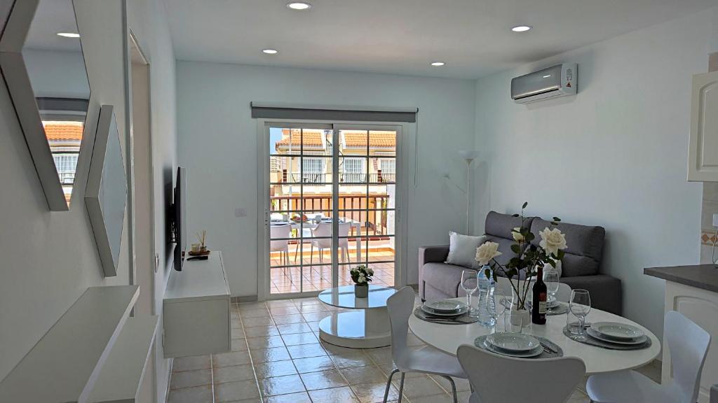 een woonkamer met een tafel en een bank bij El Mirador Sea View - Air conditioning - Los Cristianos in Los Cristianos