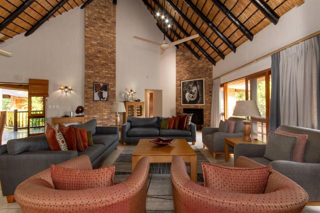 sala de estar con sofás, sillas y mesa en Kruger Park Lodge Unit No. 308, en Hazyview