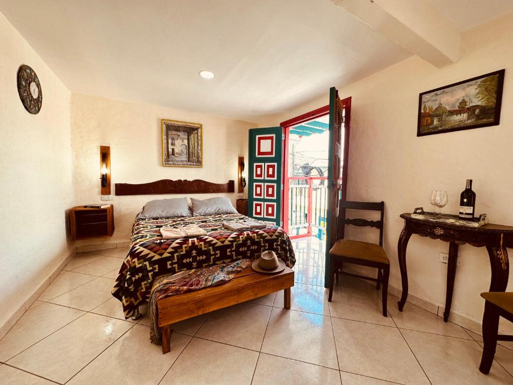 a bedroom with a bed and a table and a chair at IntiLuna Hostel in Salento