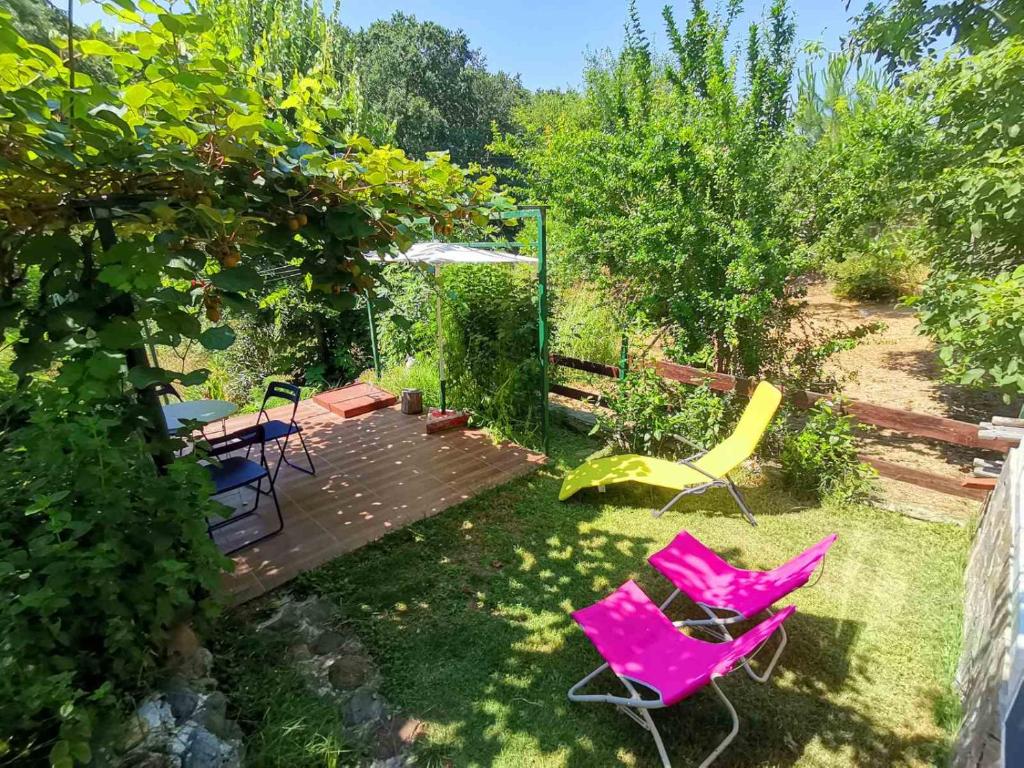 een tuin met roze stoelen en een houten terras bij Blue summer villa in Sinemorets