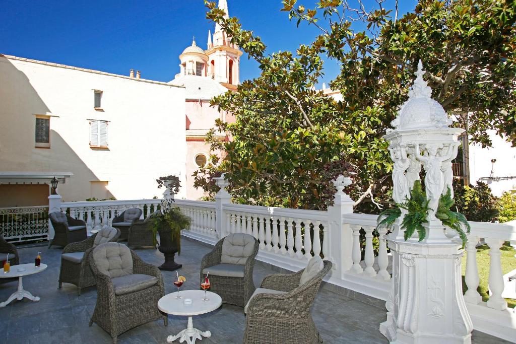 卡爾維的住宿－木蘭花酒店，一个带桌椅的庭院和白色的围栏