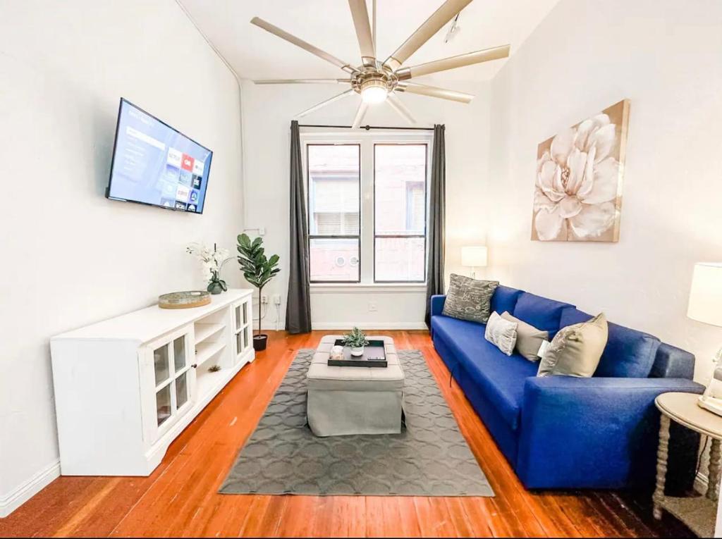 a living room with a blue couch and a tv at Gaslamp 2bdrm - W Parking & 5 Beds #303 in San Diego