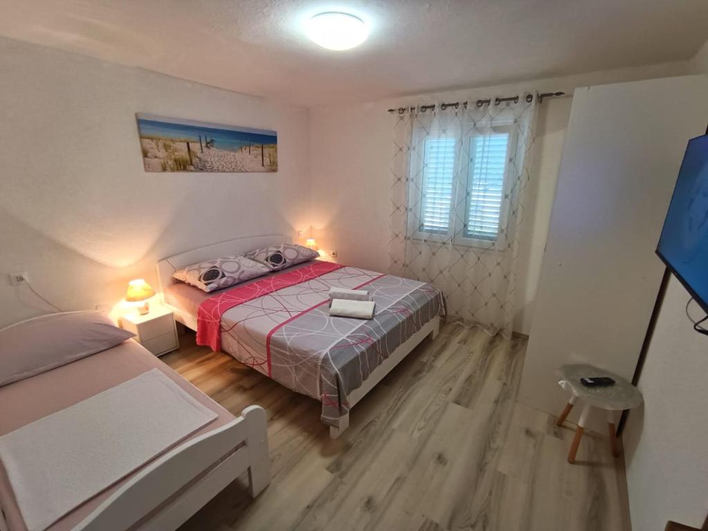 a small bedroom with a bed and a window at Guesthouse Eljuga Family in Stari Grad