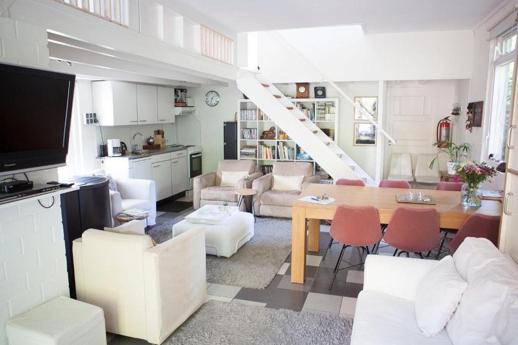 a kitchen and living room with a table and chairs at Cottage Markdal in Breda